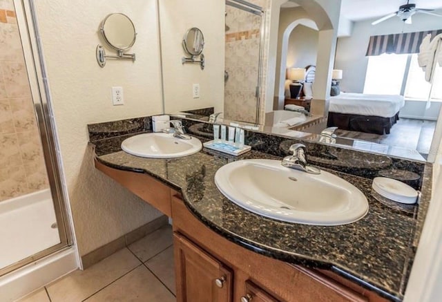 bathroom featuring a stall shower, a sink, ensuite bath, and tile patterned floors