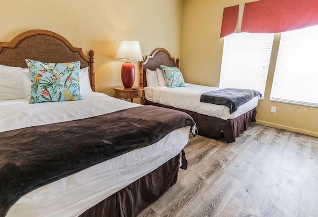 bedroom featuring baseboards and light wood-style floors