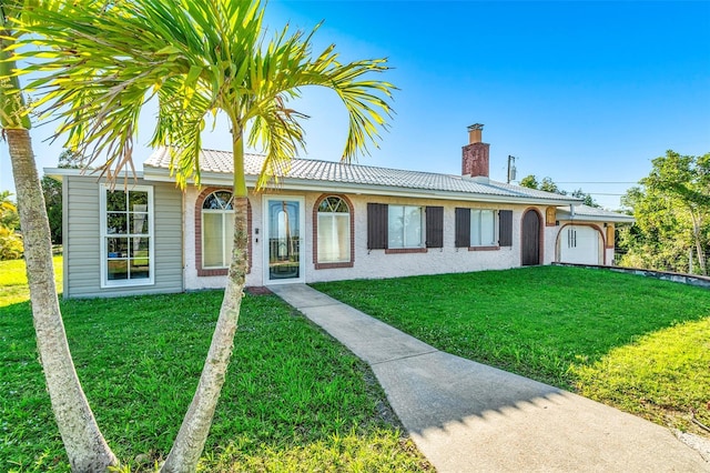 ranch-style house with a garage and a front lawn