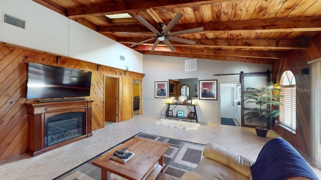 tiled living room featuring wood walls, a barn door, wooden ceiling, and high vaulted ceiling