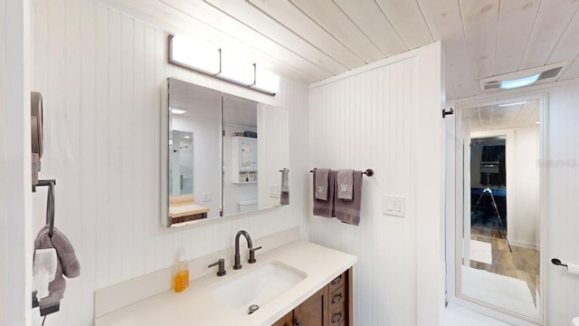 bathroom with vanity, wood walls, and wood ceiling