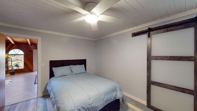 bedroom featuring a barn door, ceiling fan, hardwood / wood-style floors, and wood ceiling