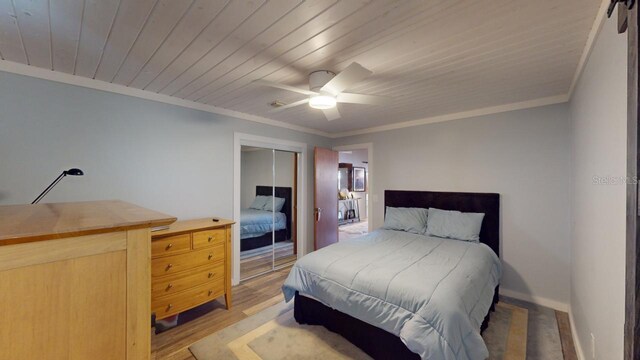 bedroom with ceiling fan, light hardwood / wood-style floors, crown molding, and a closet