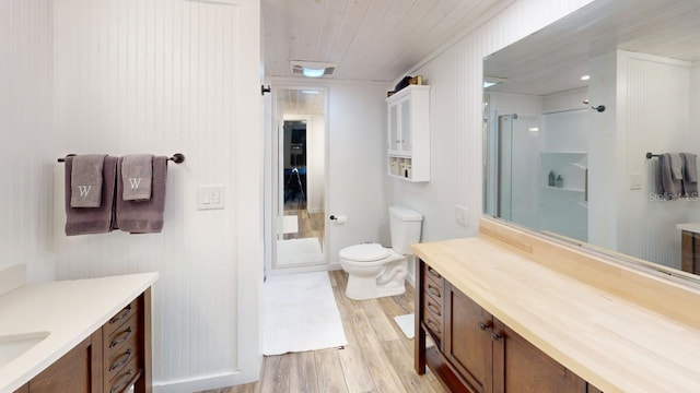 bathroom featuring wood walls, toilet, a shower with shower door, and hardwood / wood-style flooring