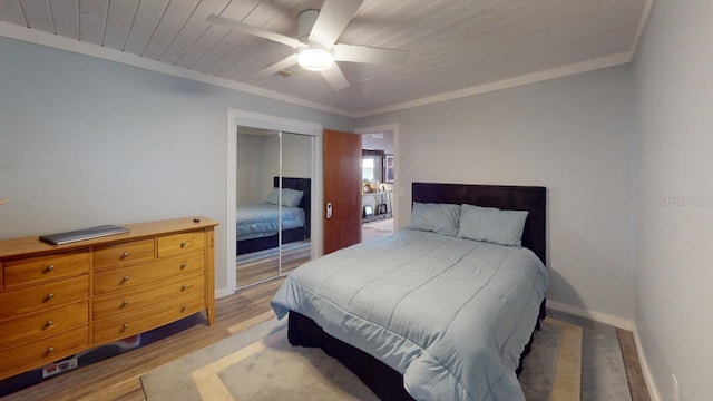 bedroom featuring a closet, light hardwood / wood-style flooring, ceiling fan, and ornamental molding