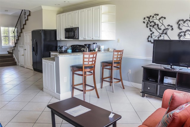 kitchen featuring black appliances, white cabinets, crown molding, light tile patterned floors, and kitchen peninsula