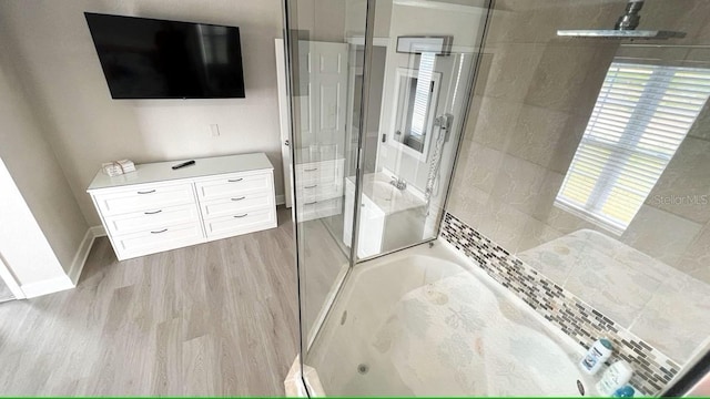 bathroom featuring wood-type flooring and plus walk in shower