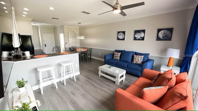 living room with light hardwood / wood-style flooring, ceiling fan, ornamental molding, and sink