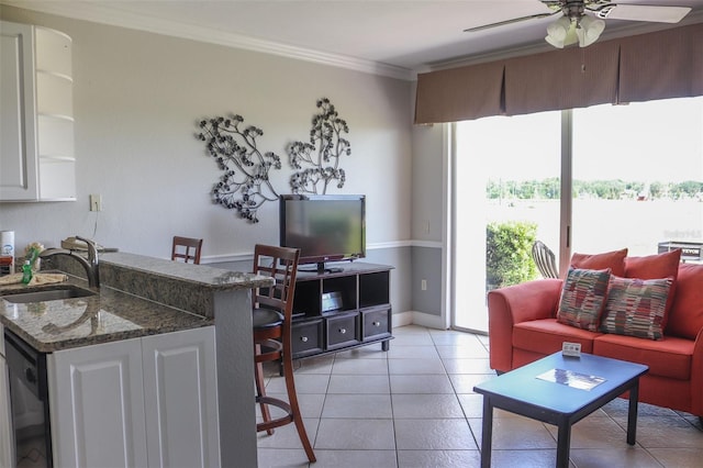 living room featuring crown molding, sink, light tile patterned flooring, and ceiling fan