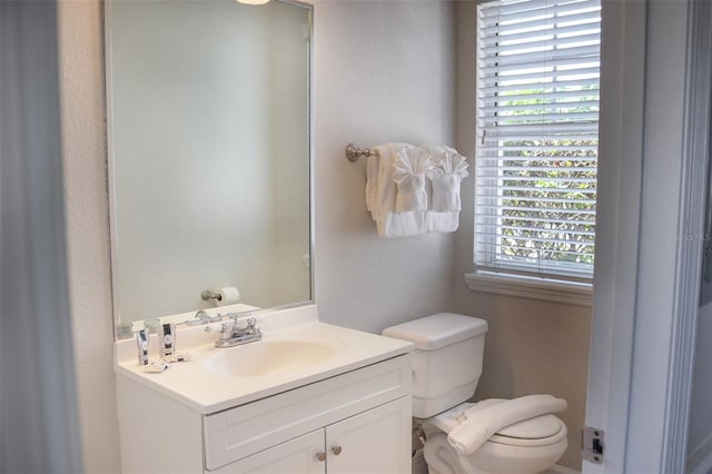 bathroom with vanity, toilet, and a healthy amount of sunlight