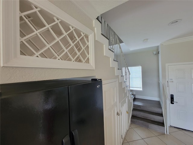 stairs with tile patterned flooring and ornamental molding