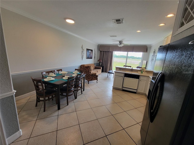 tiled dining space featuring ceiling fan and ornamental molding