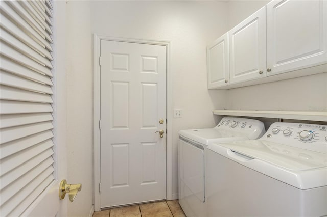 washroom with light tile patterned floors, separate washer and dryer, and cabinets