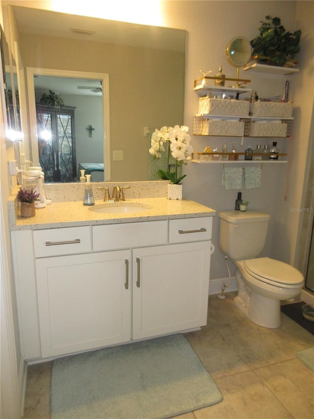 bathroom featuring vanity, tile patterned floors, and toilet