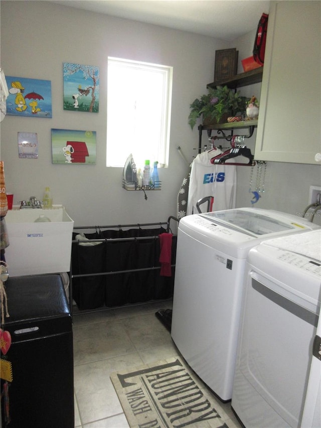 laundry area featuring separate washer and dryer, sink, and cabinets