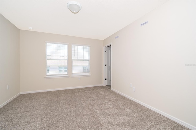 spare room featuring baseboards and carpet flooring