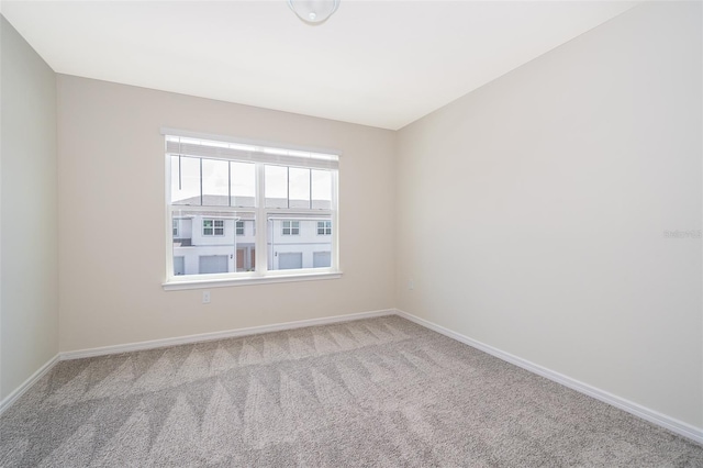 unfurnished room featuring carpet and baseboards