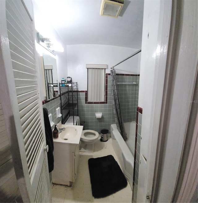 full bathroom with vanity, toilet, tile walls, and shower / tub combo with curtain