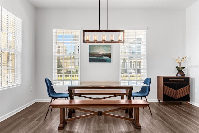 dining room with dark wood-type flooring and a notable chandelier