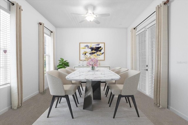 dining space with light carpet and ceiling fan