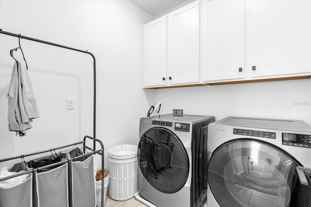 laundry area with washer and dryer and cabinets