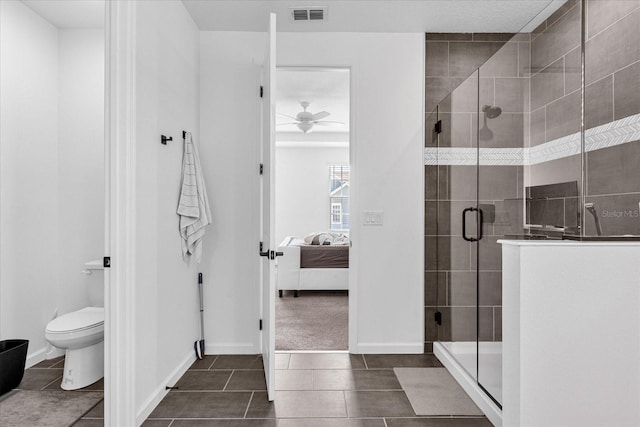 bathroom featuring tile patterned floors, a shower with door, toilet, and ceiling fan