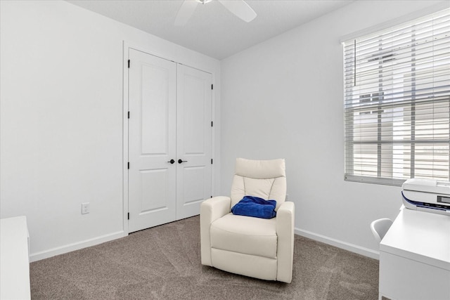 living area featuring a wealth of natural light, ceiling fan, and light colored carpet