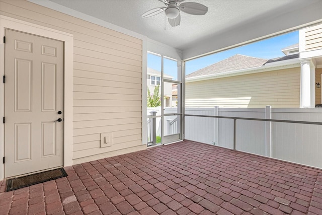 unfurnished sunroom with ceiling fan