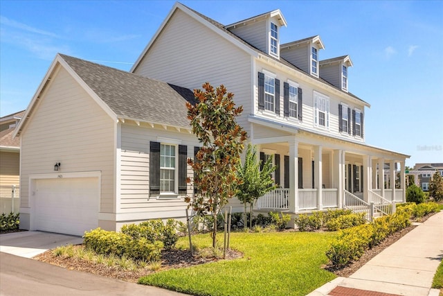 view of front of property featuring a garage, a porch, and a front yard