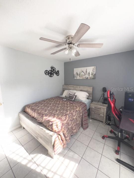 tiled bedroom with a ceiling fan