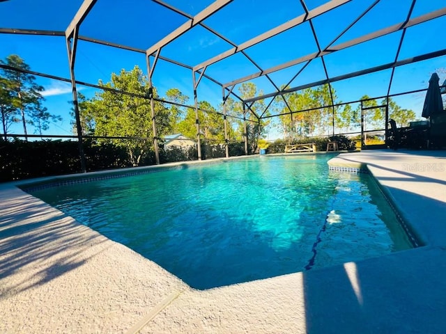 view of pool featuring glass enclosure