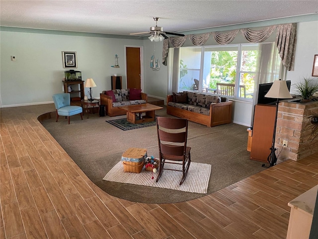 living room with ceiling fan and a textured ceiling