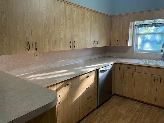 kitchen with sink, light brown cabinets, tasteful backsplash, stainless steel dishwasher, and hardwood / wood-style floors