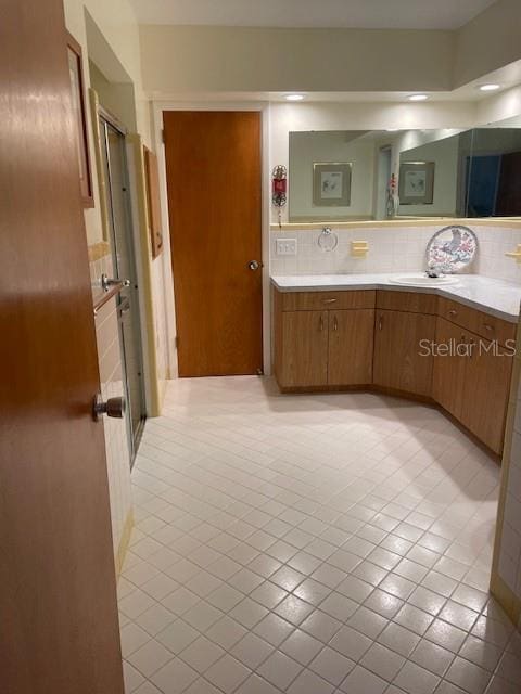 bathroom with tile patterned flooring, vanity, and backsplash