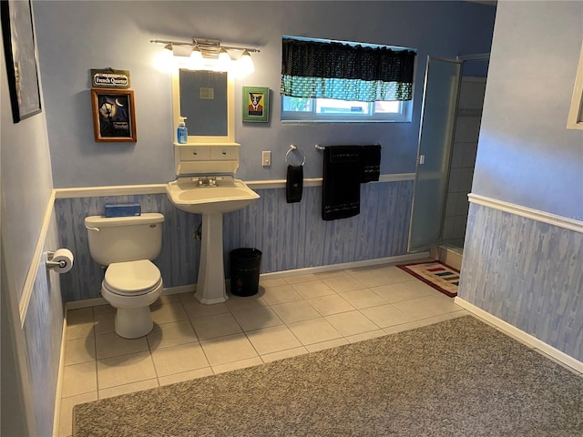 bathroom featuring tile patterned floors, a shower with shower door, and toilet