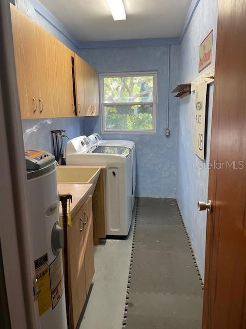 washroom with cabinets, electric water heater, and washing machine and clothes dryer