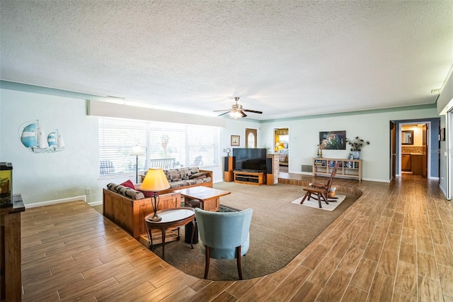 3240 San Mateo St, Clearwater, FL 33759 - living room featuring wood finished floors, a textured ceiling, a ceiling fan, and baseboards