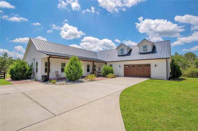 modern farmhouse with a garage, central air condition unit, and a front lawn