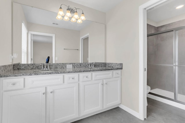 bathroom featuring a shower with shower door, tile flooring, dual vanity, and toilet