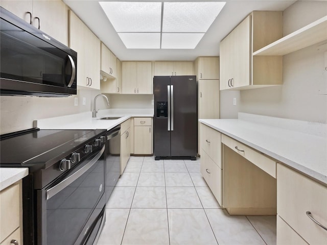 kitchen featuring light tile patterned floors, sink, and black appliances