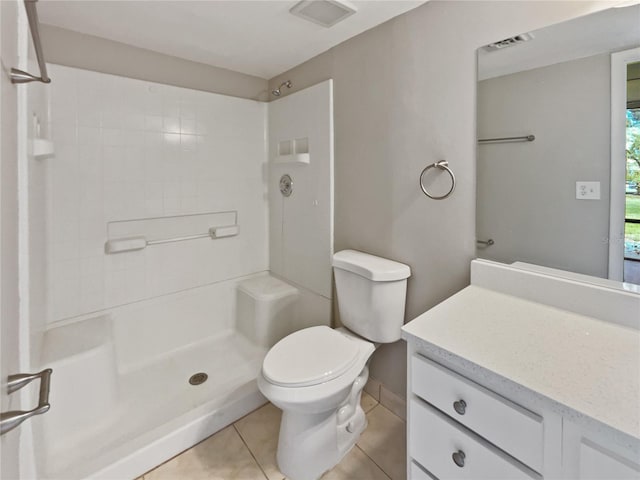 bathroom featuring a shower, tile patterned flooring, vanity, and toilet