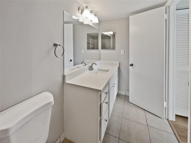 bathroom with tile patterned flooring, vanity, and toilet