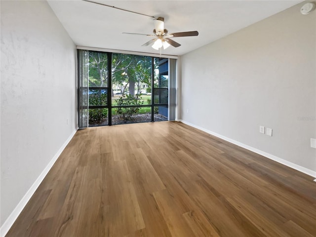 spare room featuring hardwood / wood-style flooring, ceiling fan, and floor to ceiling windows