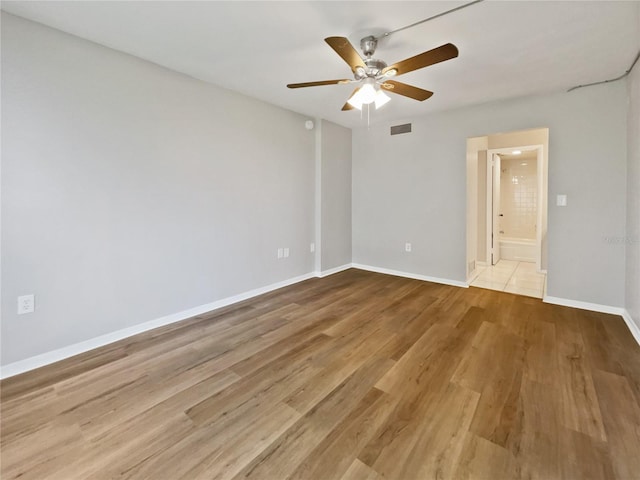 spare room with ceiling fan and light wood-type flooring