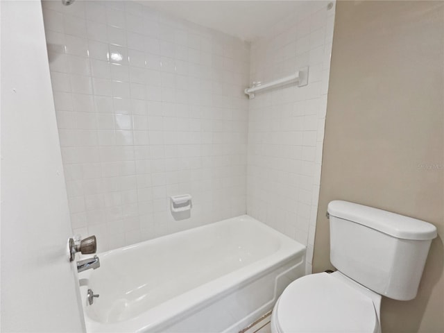 bathroom with toilet and tiled shower / bath