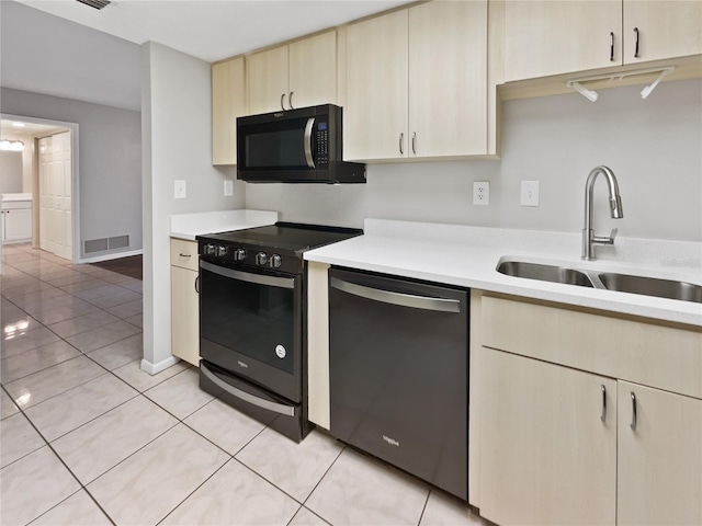 kitchen with stainless steel dishwasher, light tile patterned floors, sink, and black range with electric cooktop