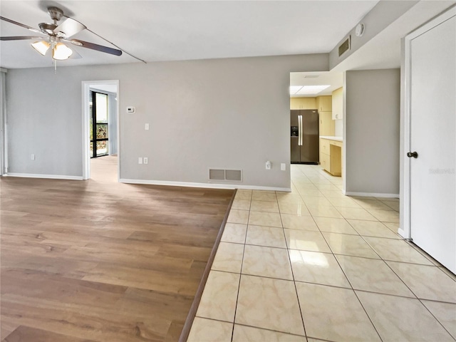 empty room featuring ceiling fan and light tile patterned flooring