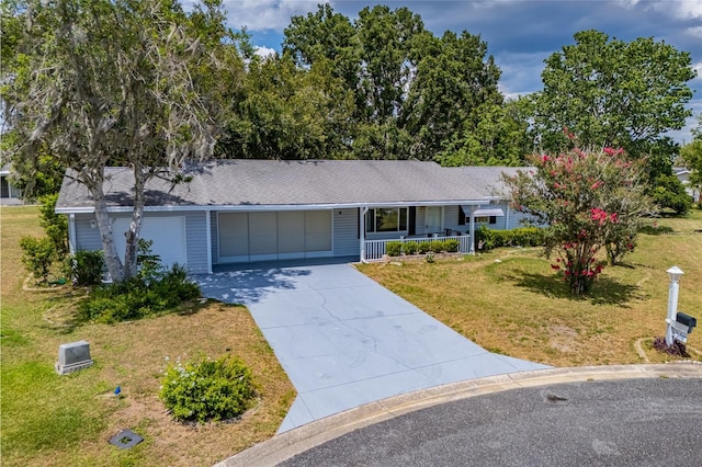 single story home featuring a front lawn, covered porch, and a garage