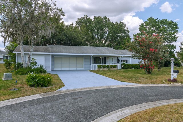 ranch-style home featuring a porch, a garage, and a front lawn