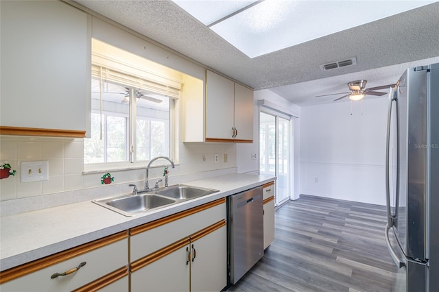 kitchen with white cabinets, a textured ceiling, stainless steel appliances, and sink